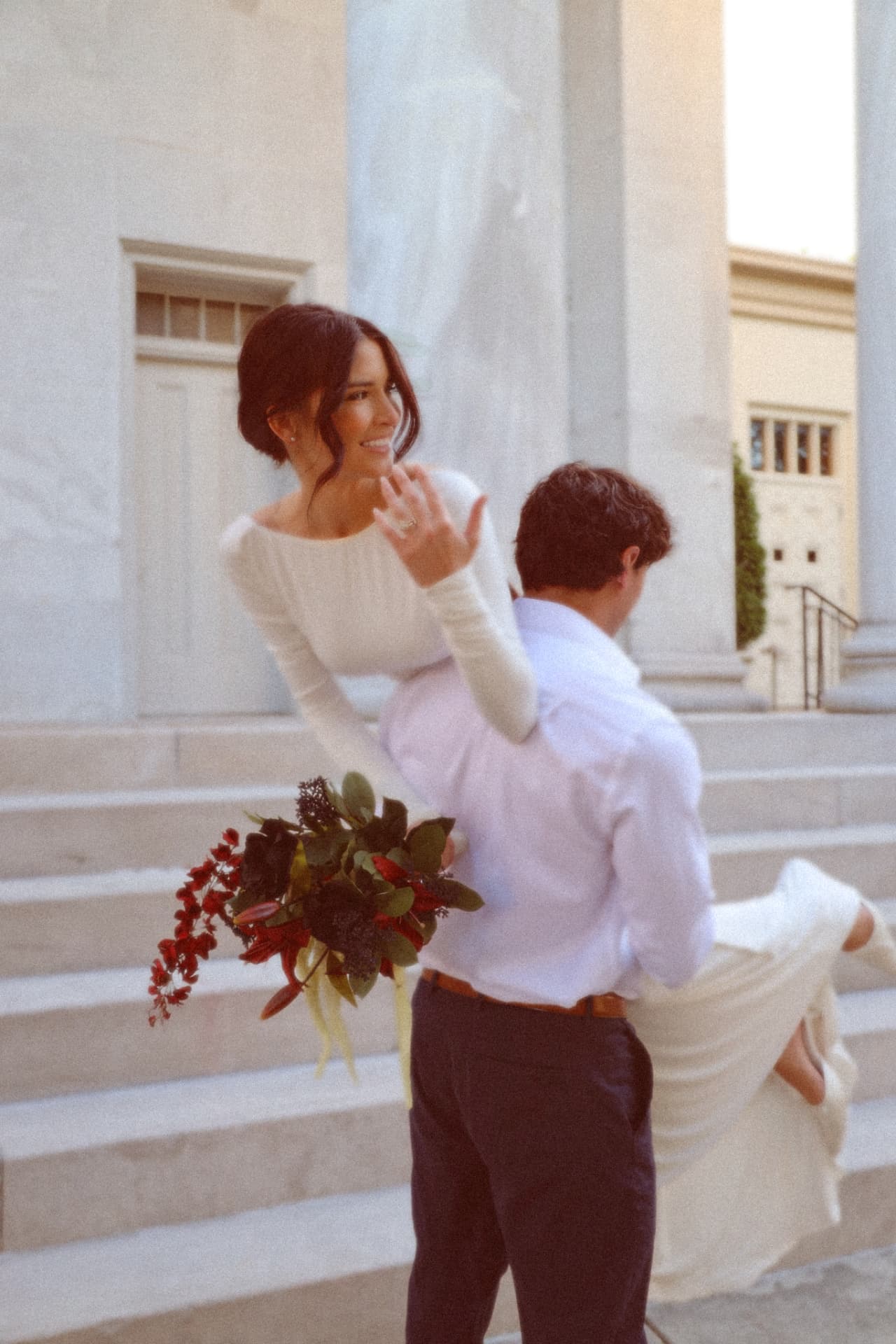 Groom carrying his bride over his shoulder down marble steps