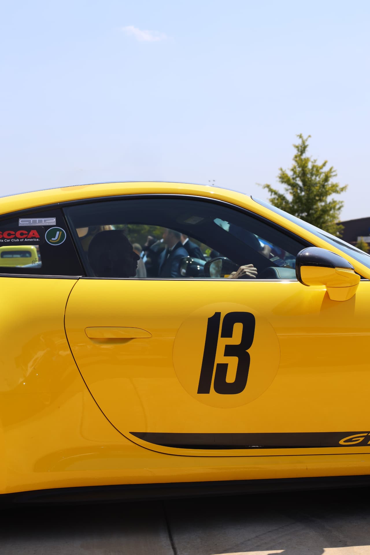 Yellow Porsche 911 GT3 with racing number 13 at a rally
