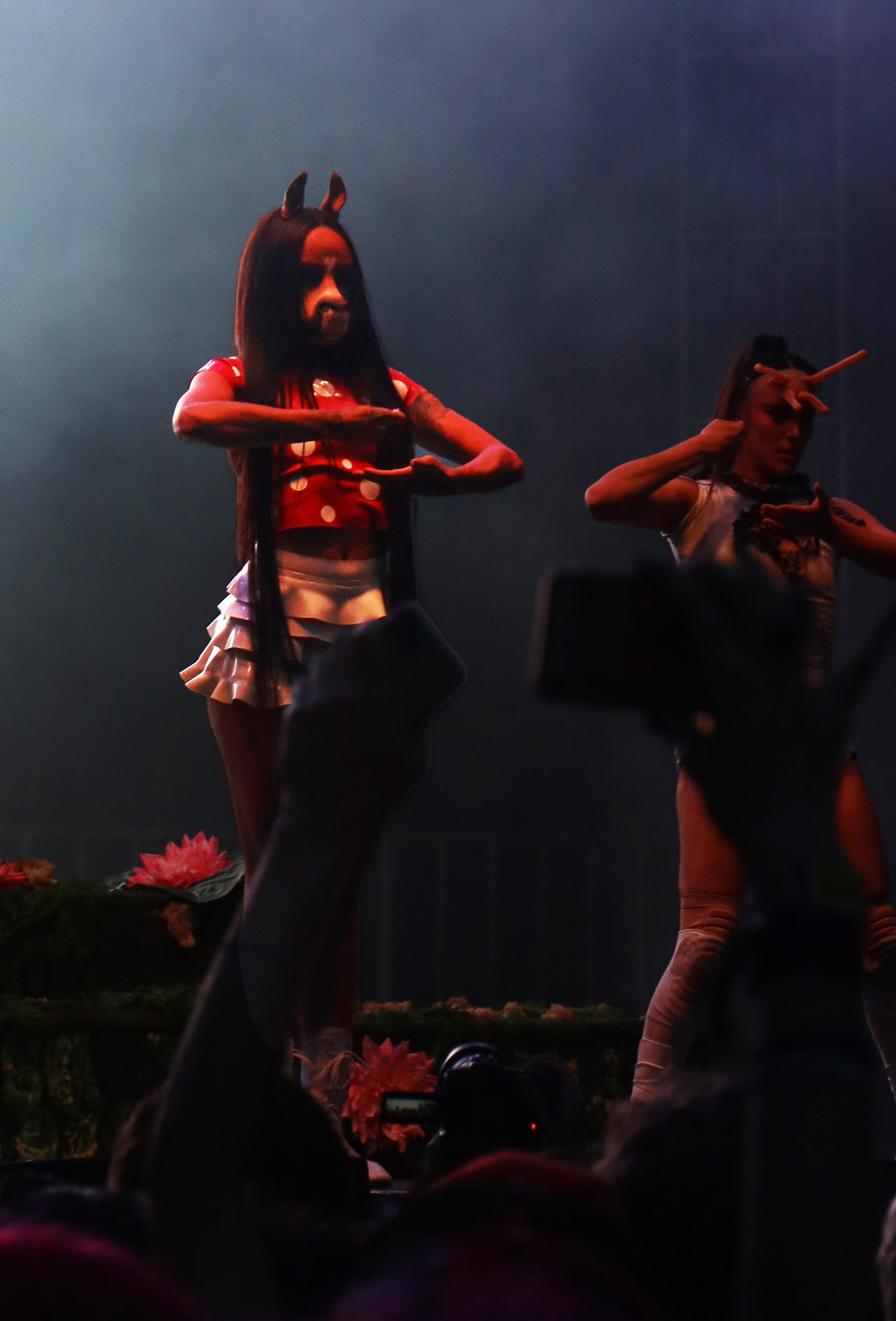 Vocalist and dancer mid choreography in low stage smoke