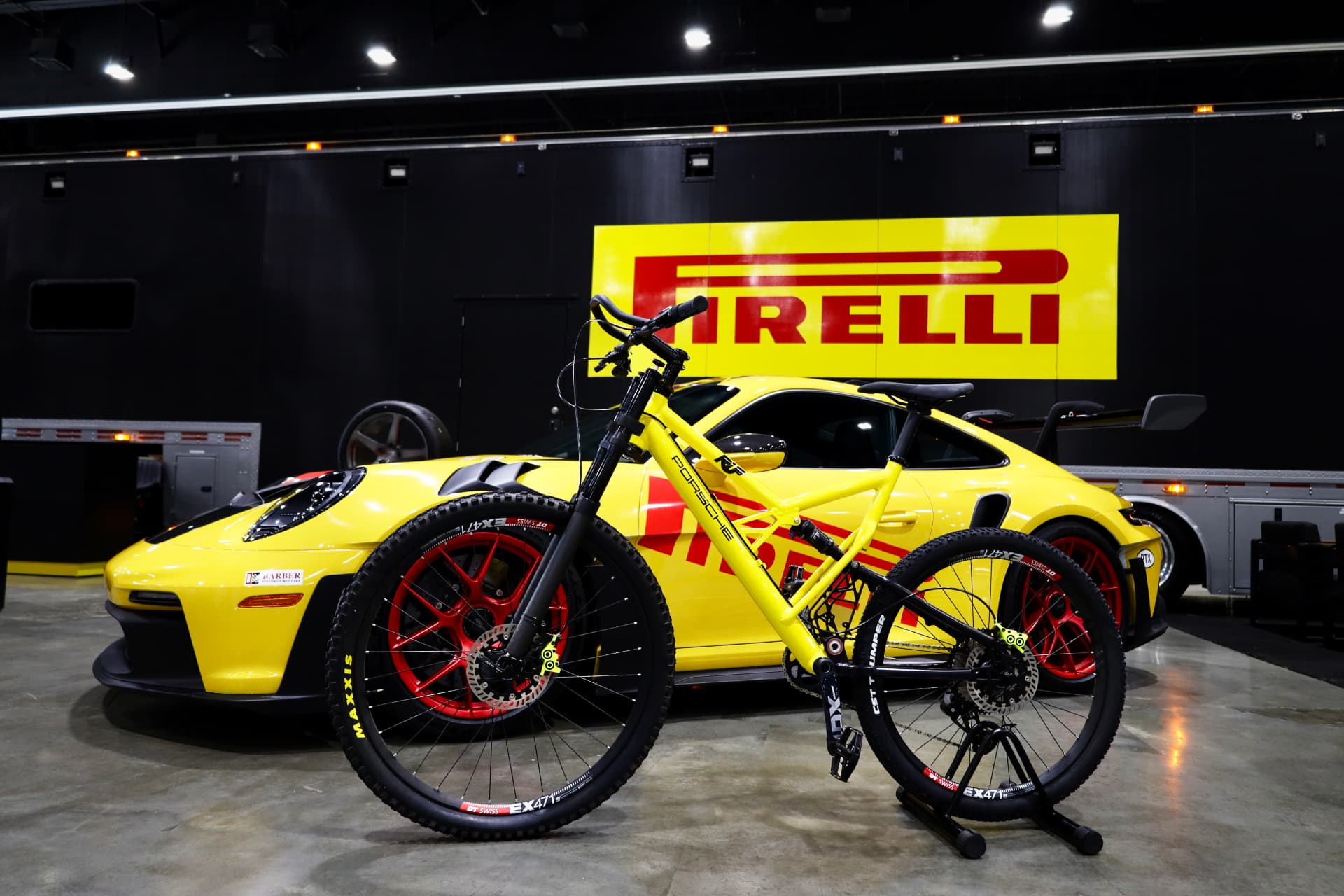 Yellow mountain bike staged in front of a yellow Porsche 911 GT3 RS at a Pirelli display