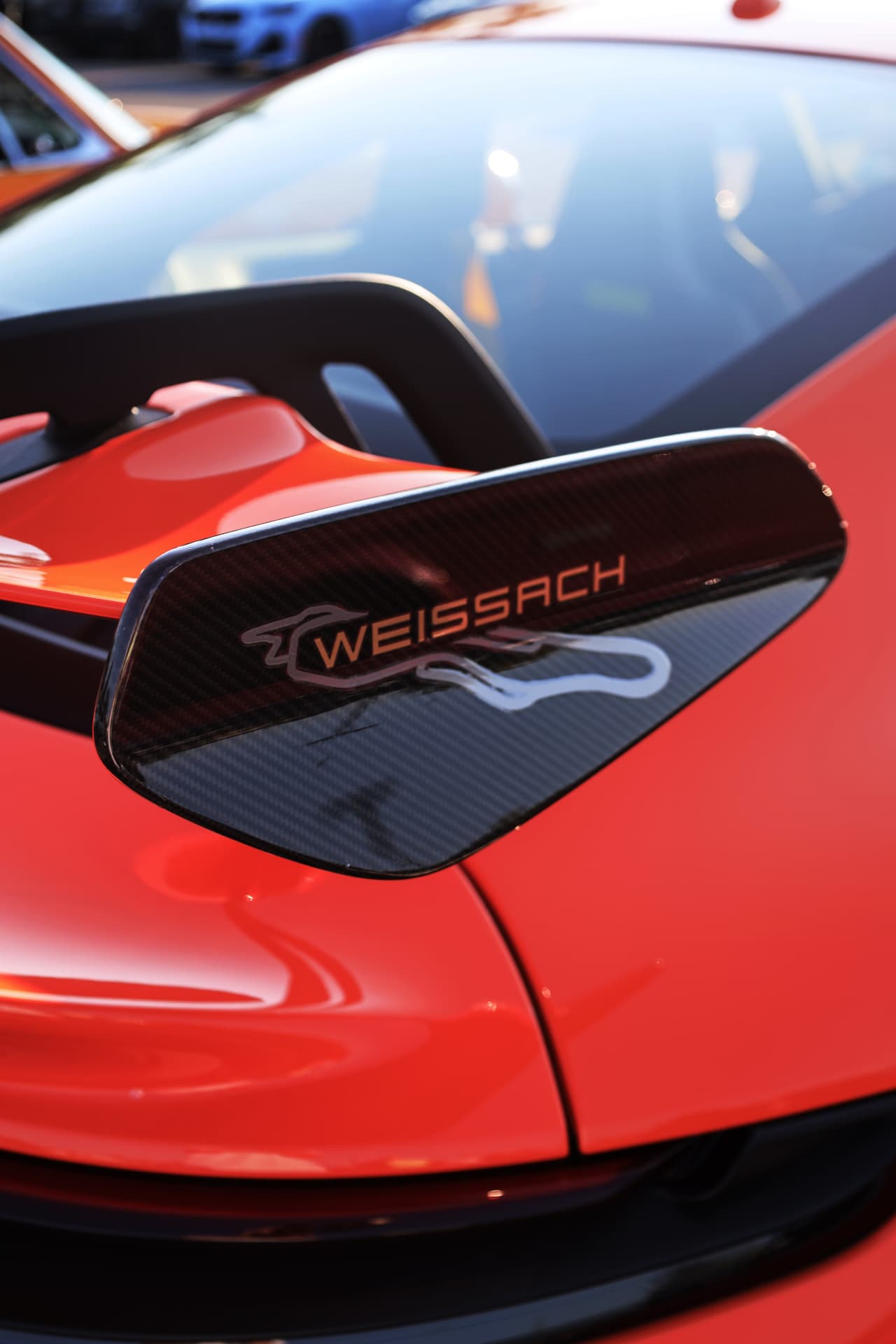 Carbon fiber Weissach wing mirror detail on a red Porsche GT3 RS