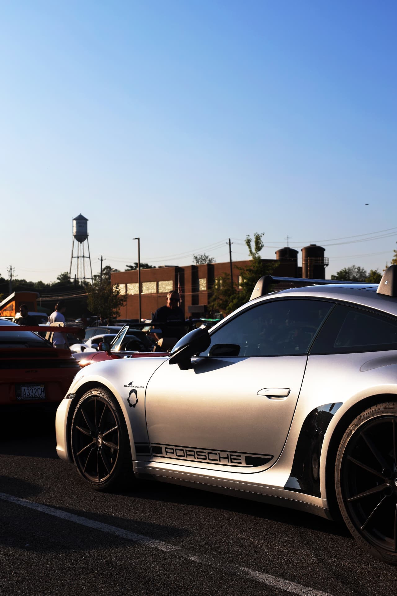Silver Porsche 911 GT3 in warm afternoon light at an outdoor car gathering
