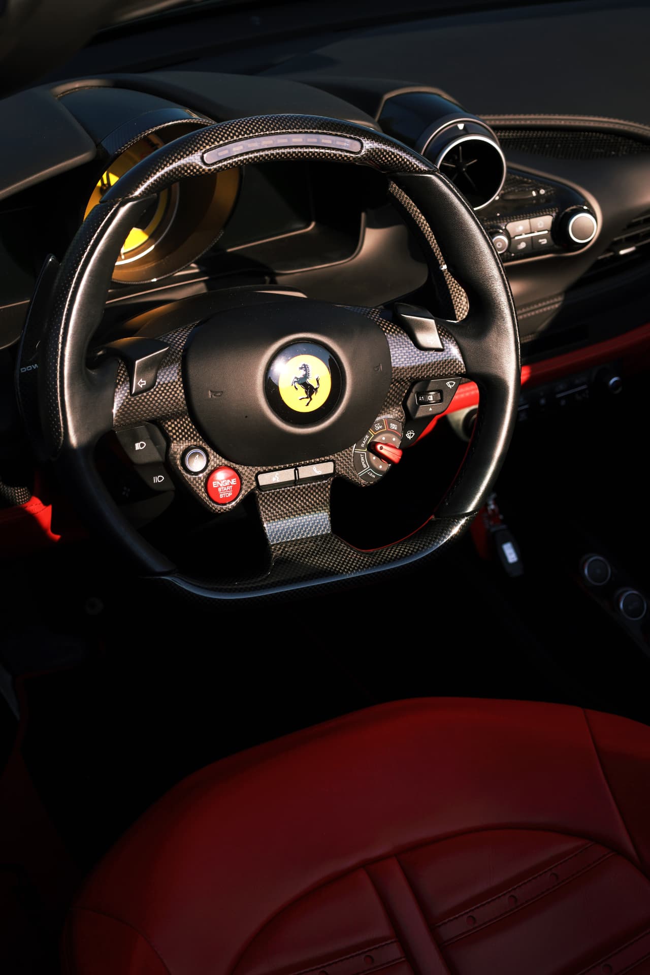 Ferrari carbon fiber steering wheel and red leather interior detail