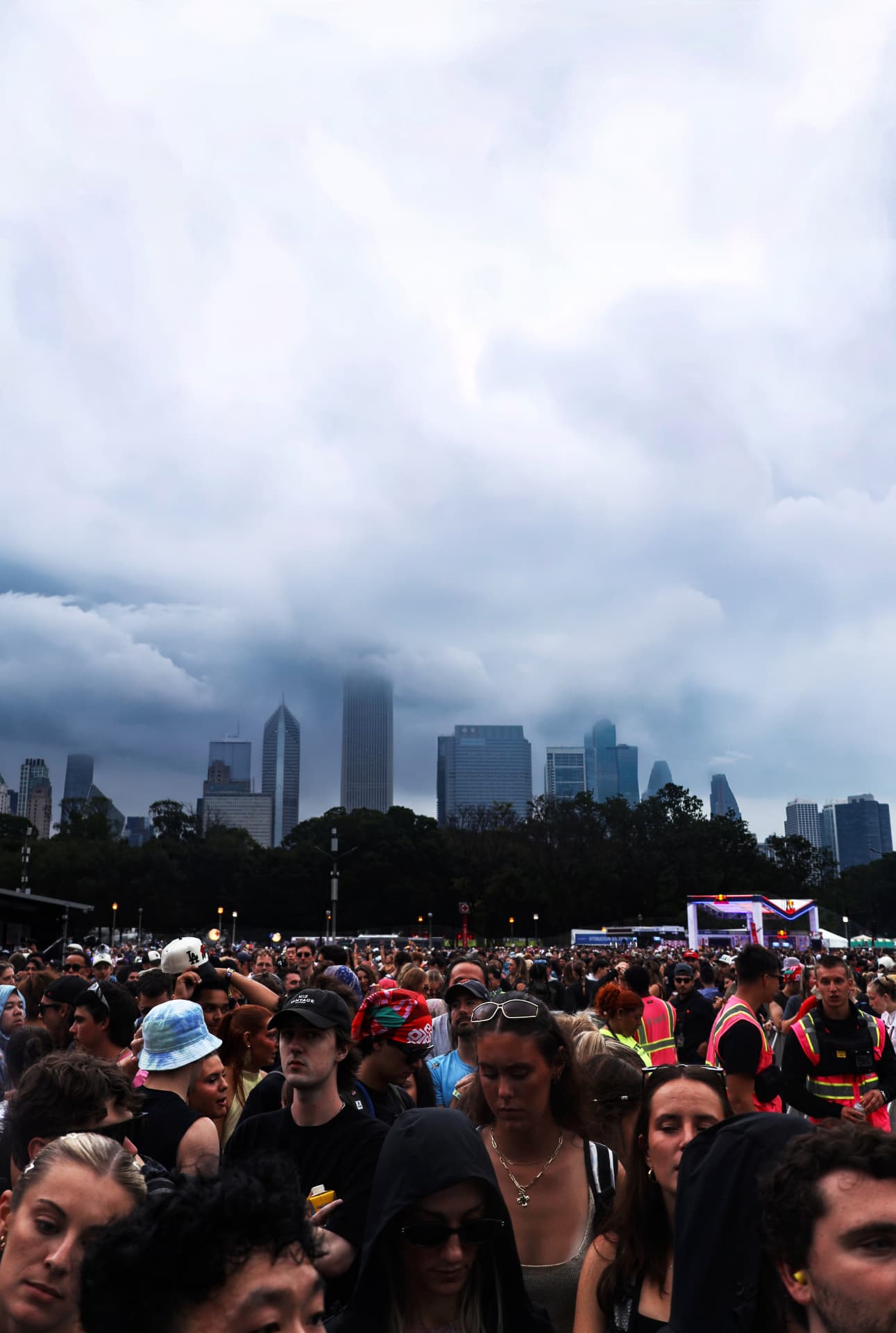 Festival crowd under storm clouds with the Chicago skyline behind