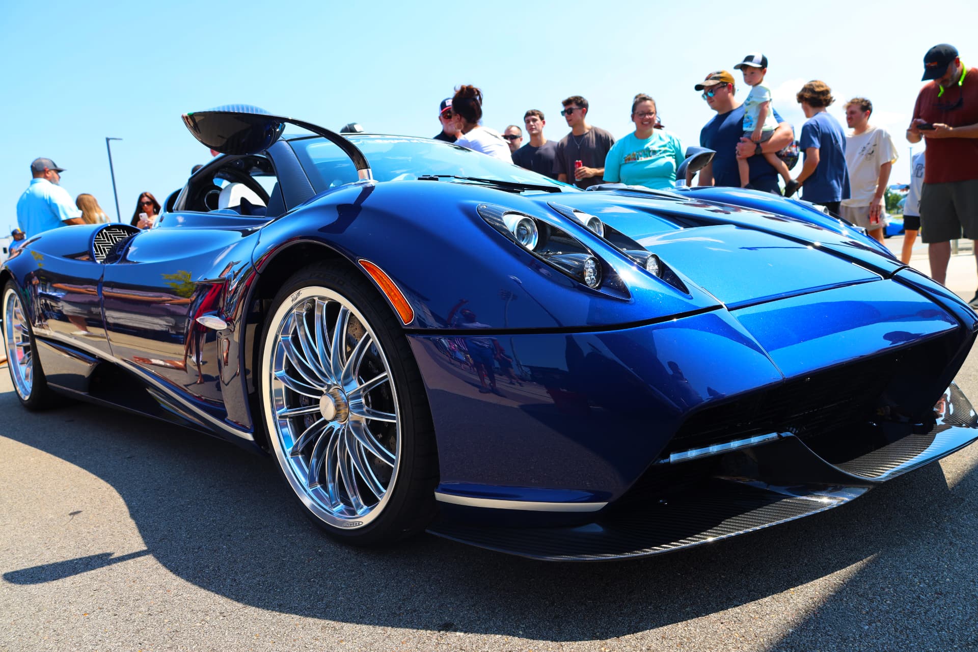 Blue Pagani Huayra at an exotic car rally with crowd