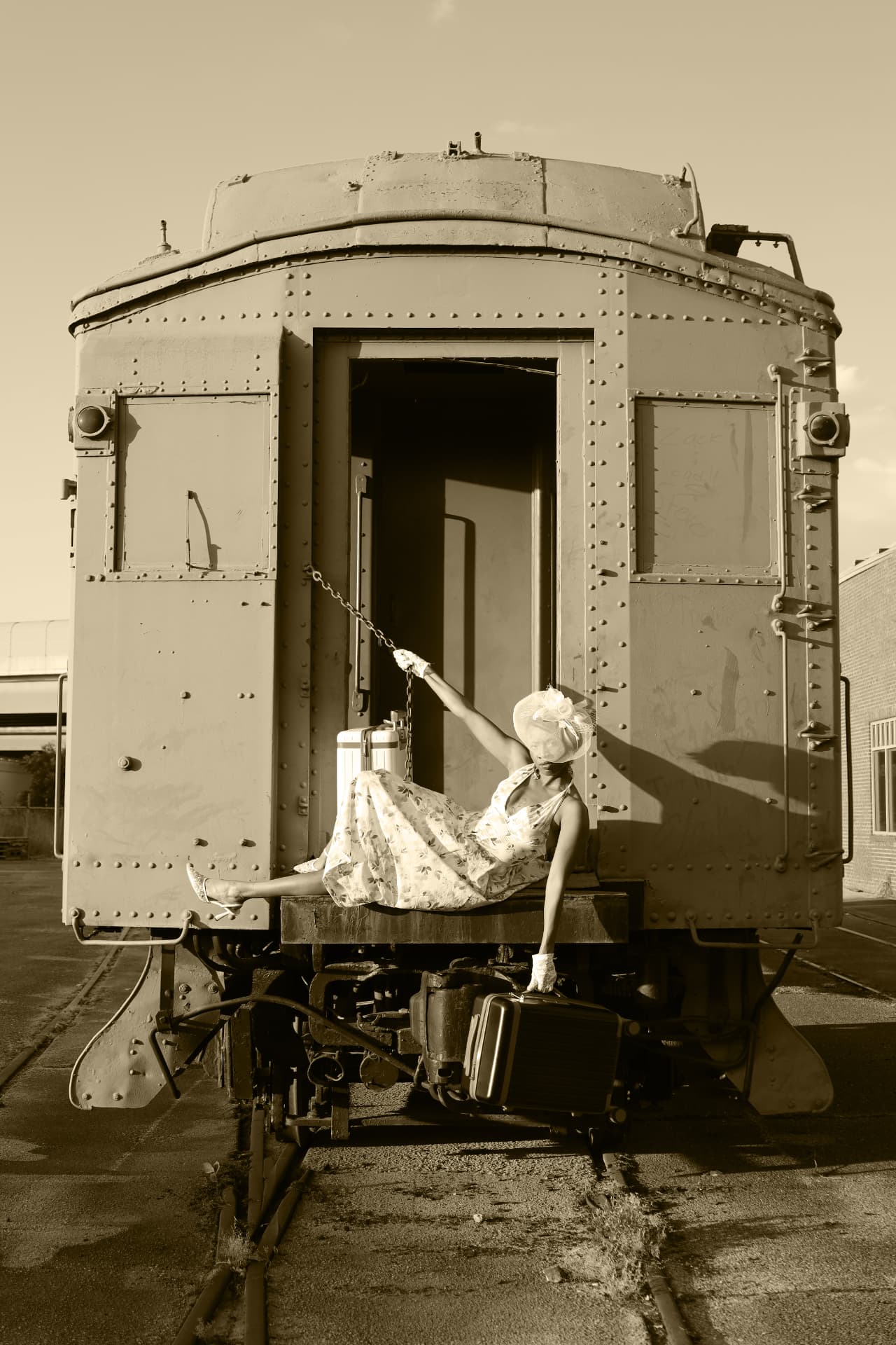 Sepia frame of a model reclining on the platform of a vintage rail car