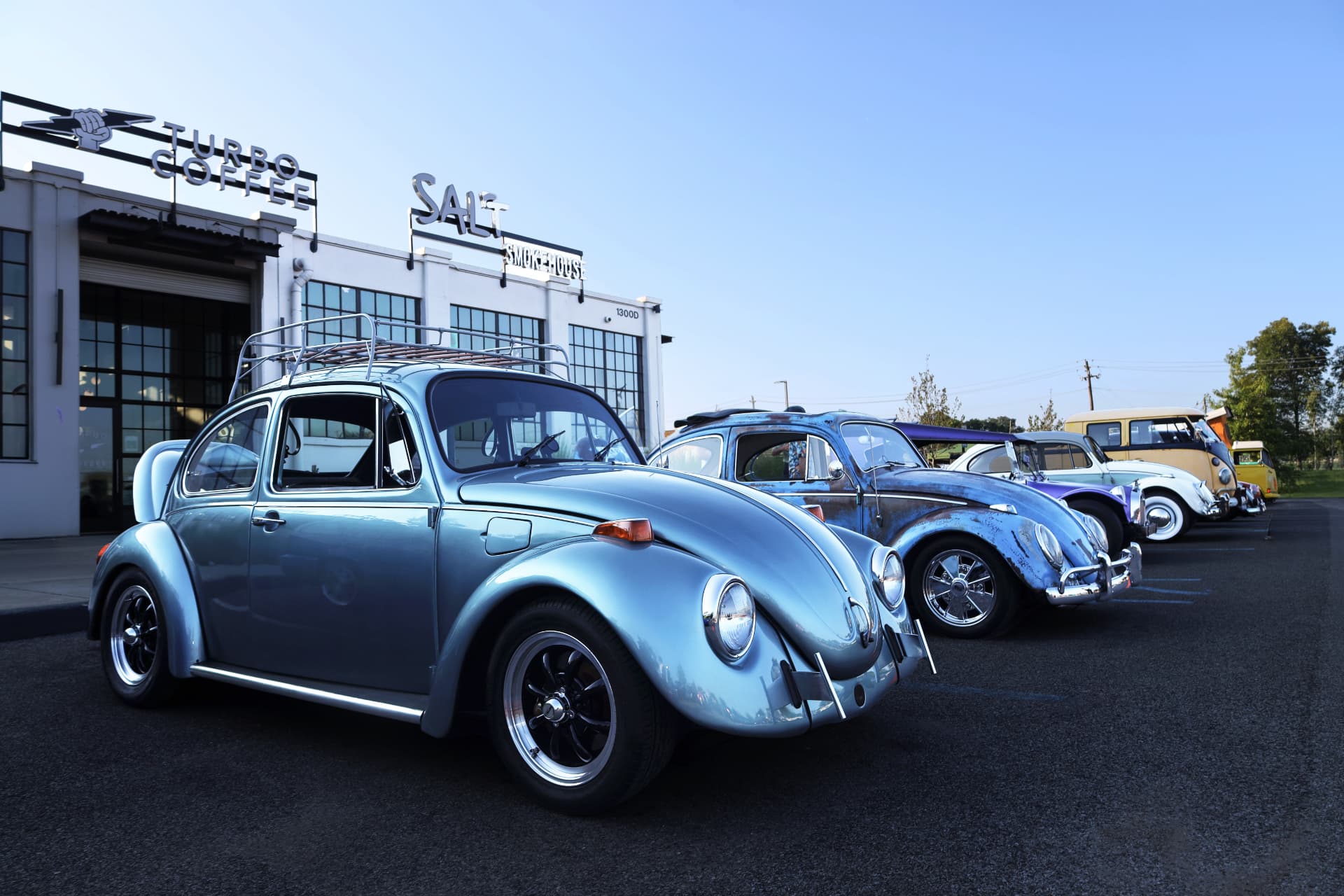 Row of vintage Volkswagen Beetles outside Turbo Coffee and Salt Smokehouse