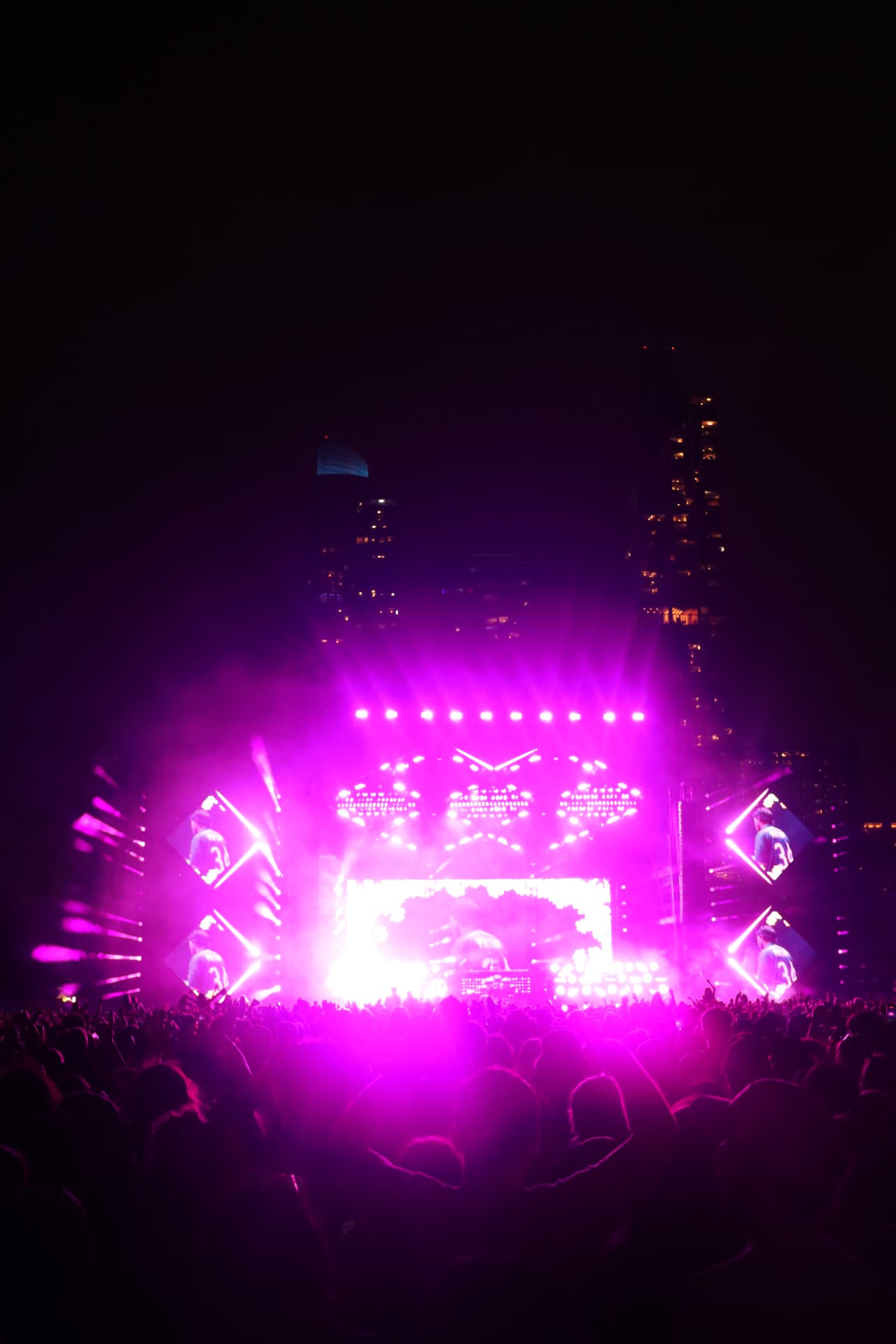 Main stage bathed in purple light with the city skyline behind